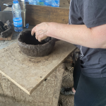 images of someone's ahnd and arm in the process of making a clay pot